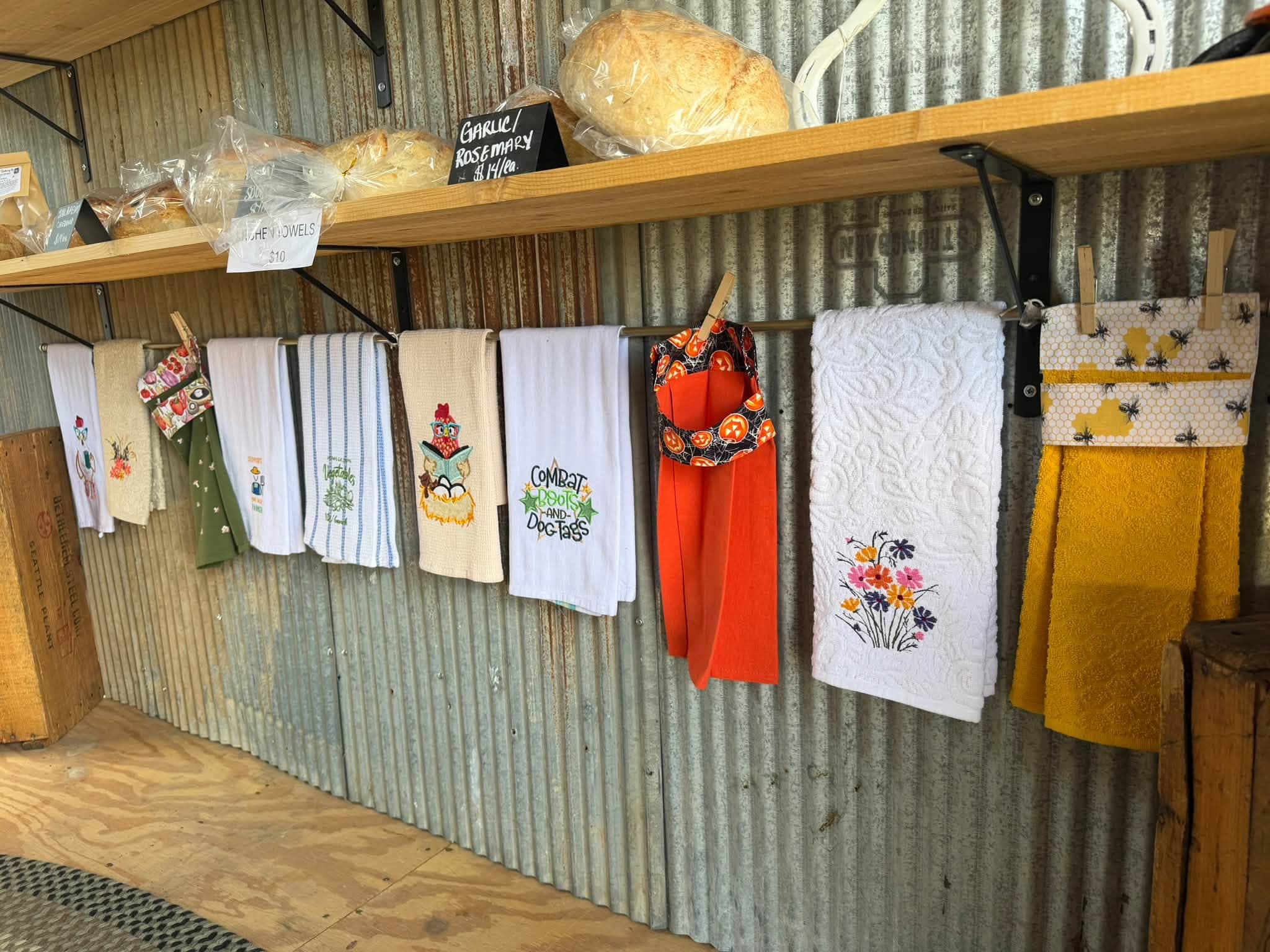 Embroidered kitchen towels, aprons, and textiles hanging on display